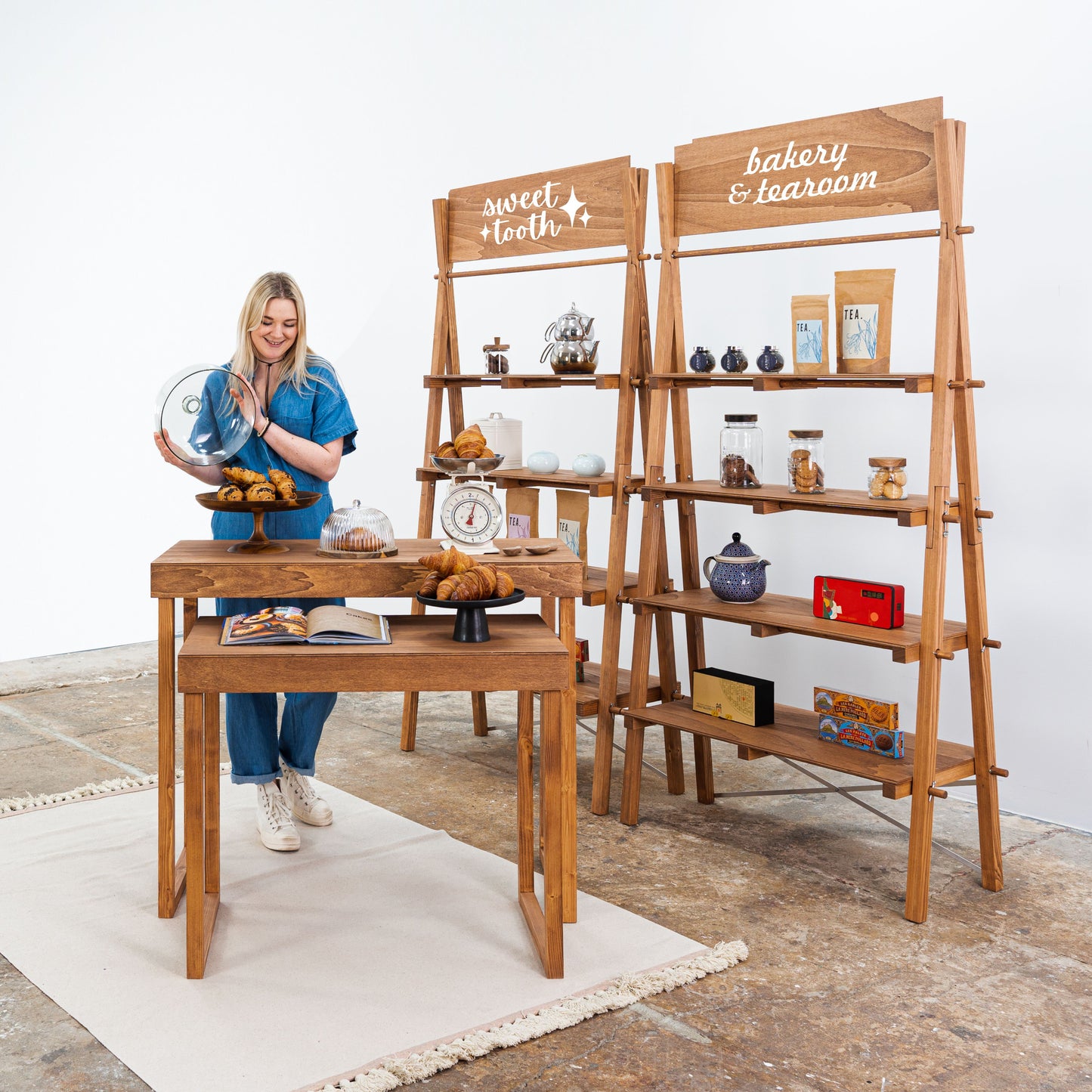Pop-up market booth with display tables and wooden shelves