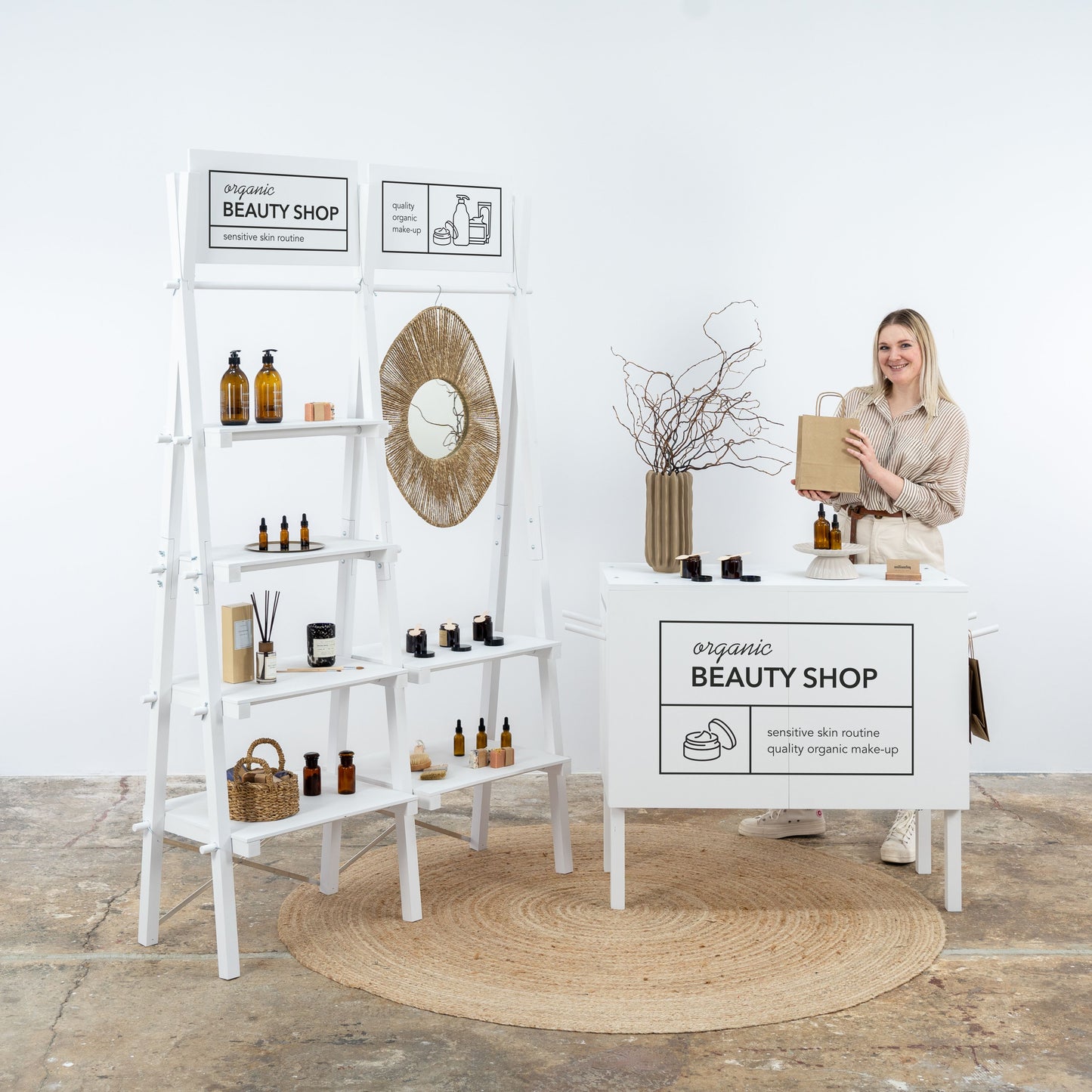 White modular trade show booth set with collapsible counter and shelving unit
