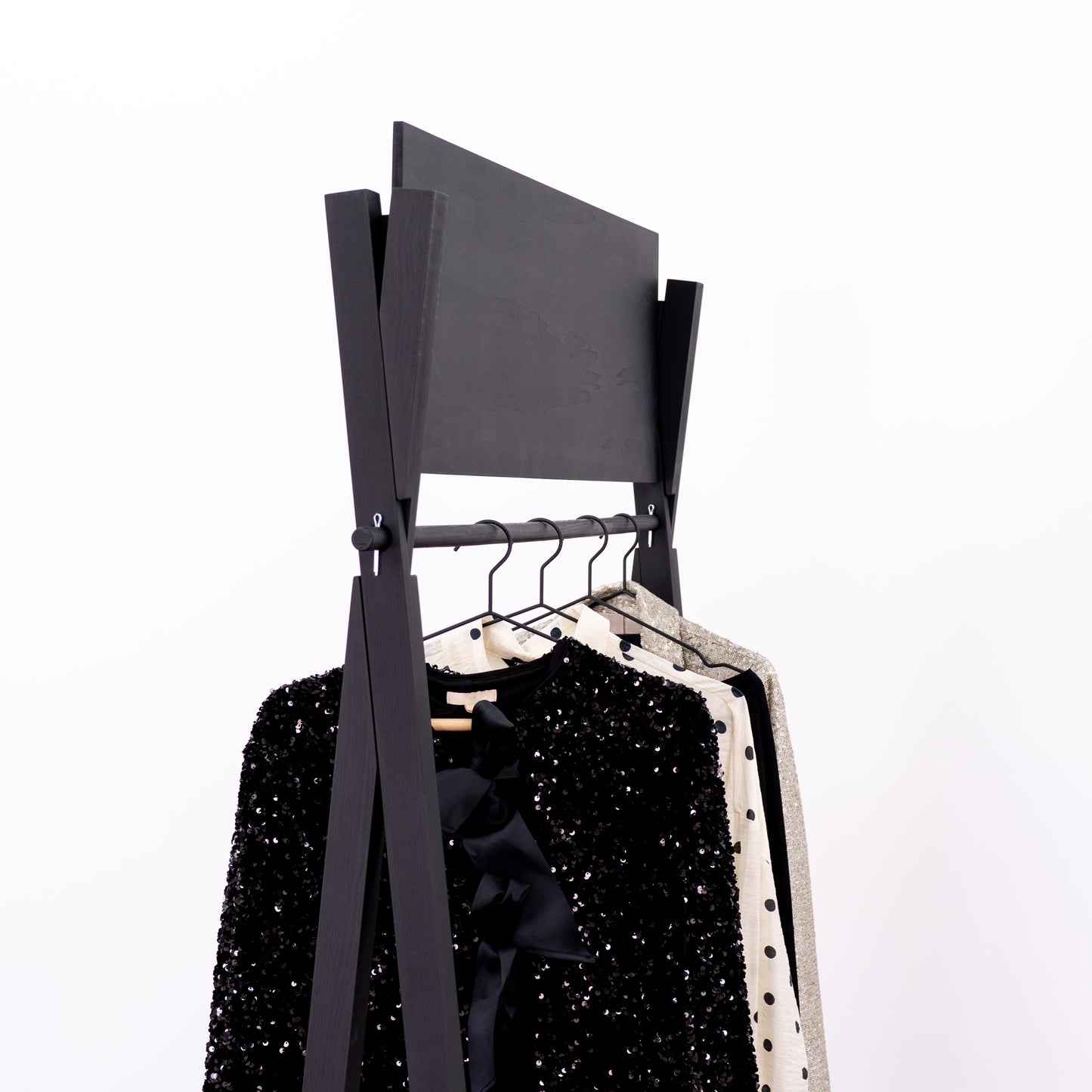 Minimalist black retail rack with robe, heels and accessories