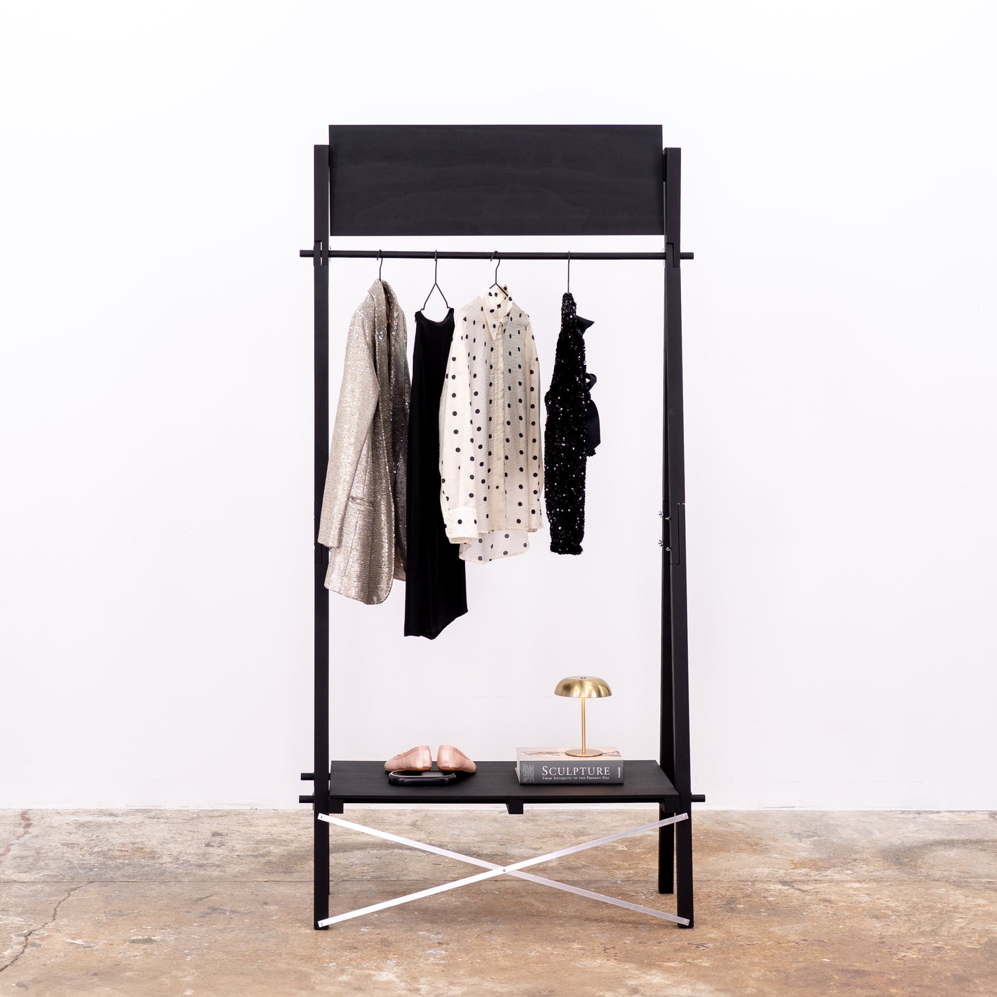 A-frame black clothing rack with shoes and lamp on lower shelf