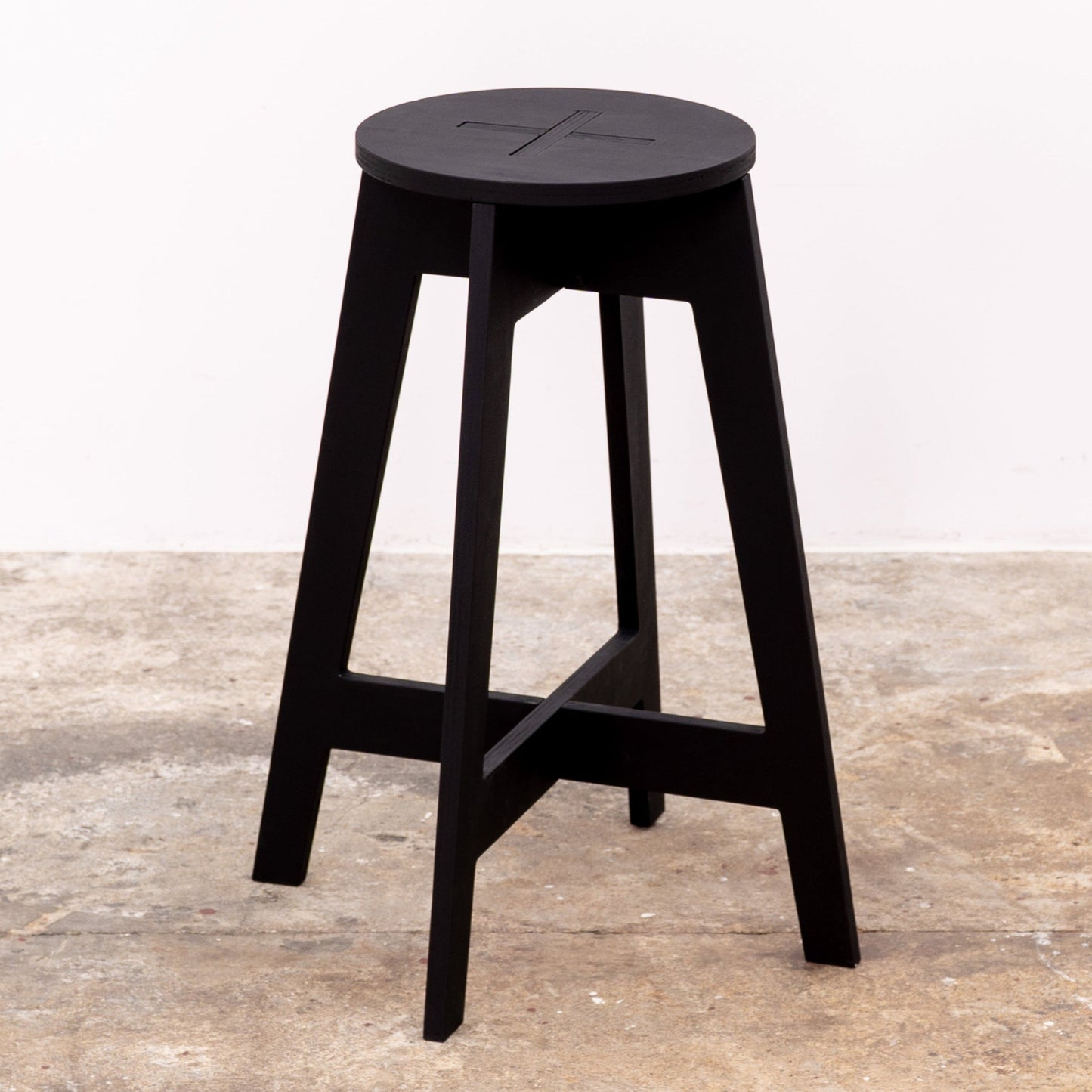 Compact black stool styled with modular display furniture