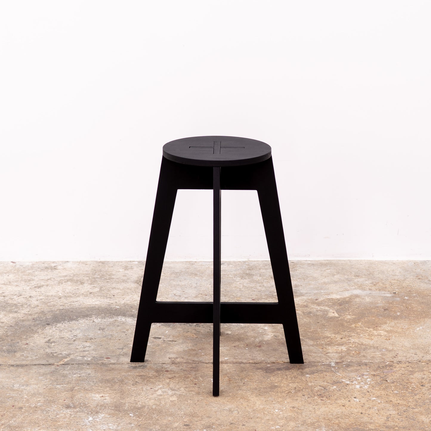 Minimalist matte black bar stool folded for transport
