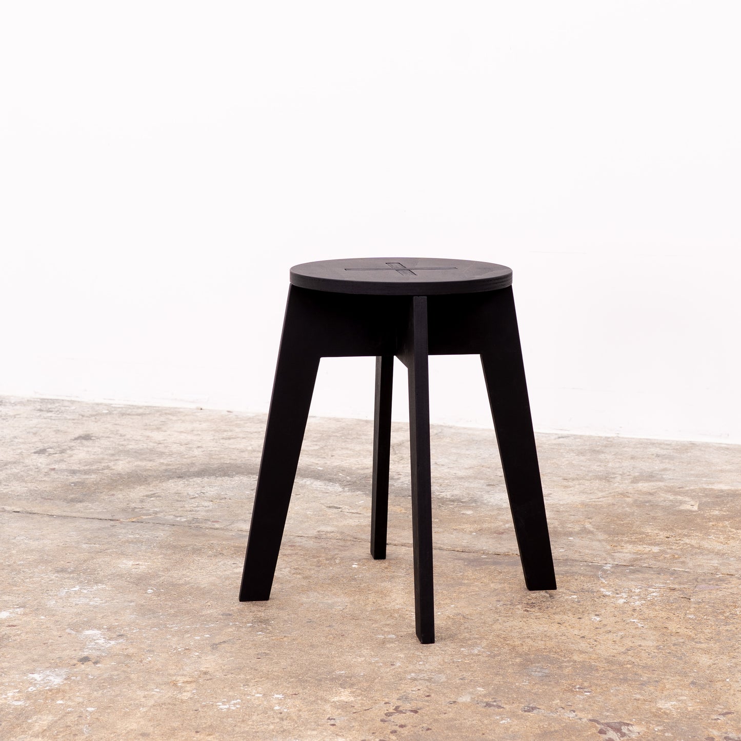 Matte black stool made of birch plywood folded flat