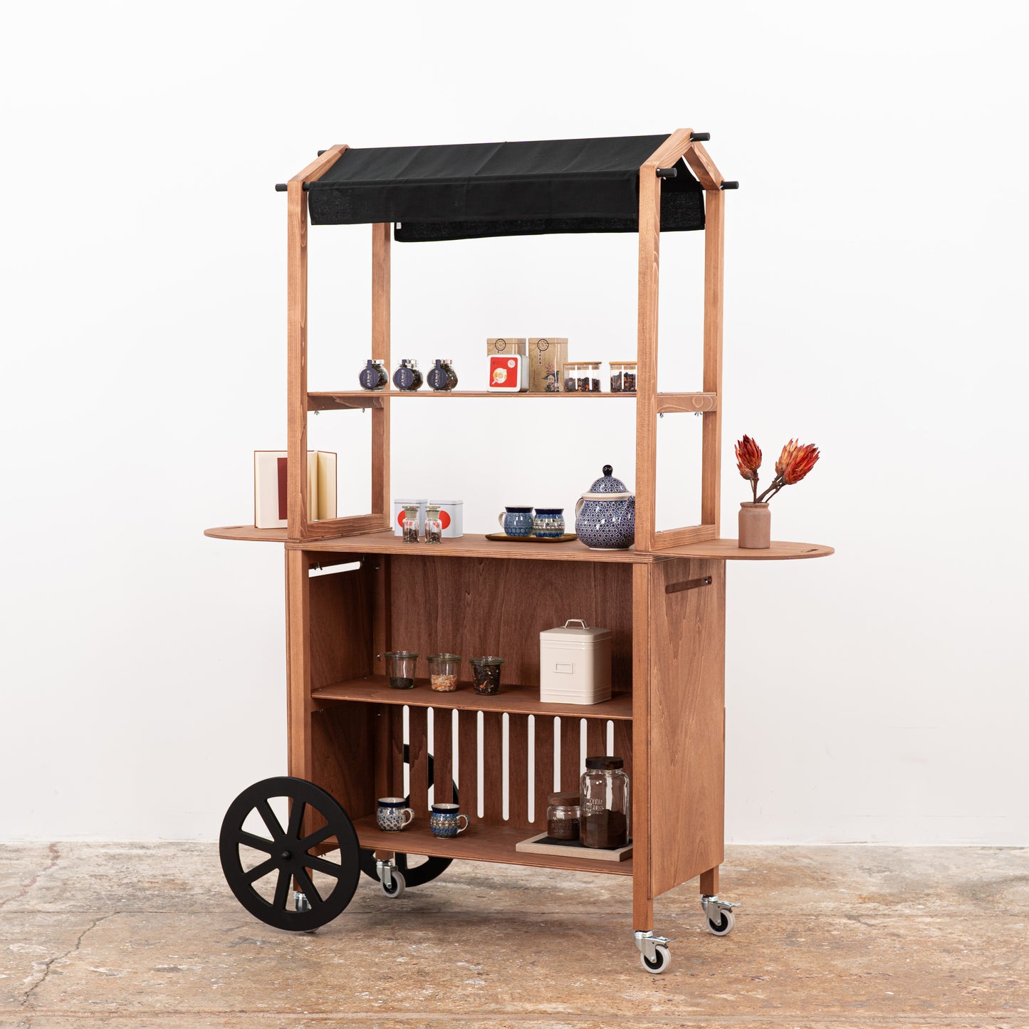 Dark wooden event cart with ceramic products on display