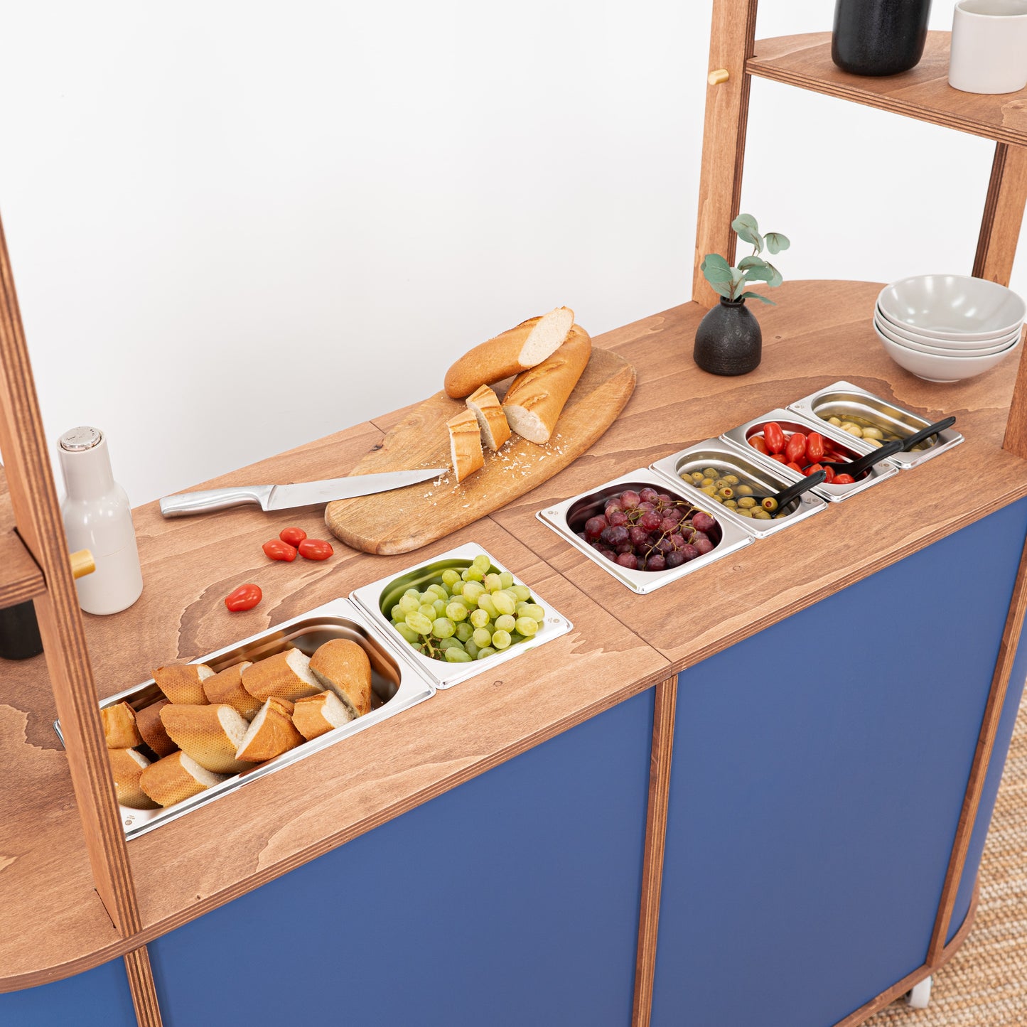 VC-29-A-W Charcuterie Cart with cut-out spaces for bain-maries, wooden covers, and sleek design for displaying gourmet appetizers and drinks at events or trade shows.
