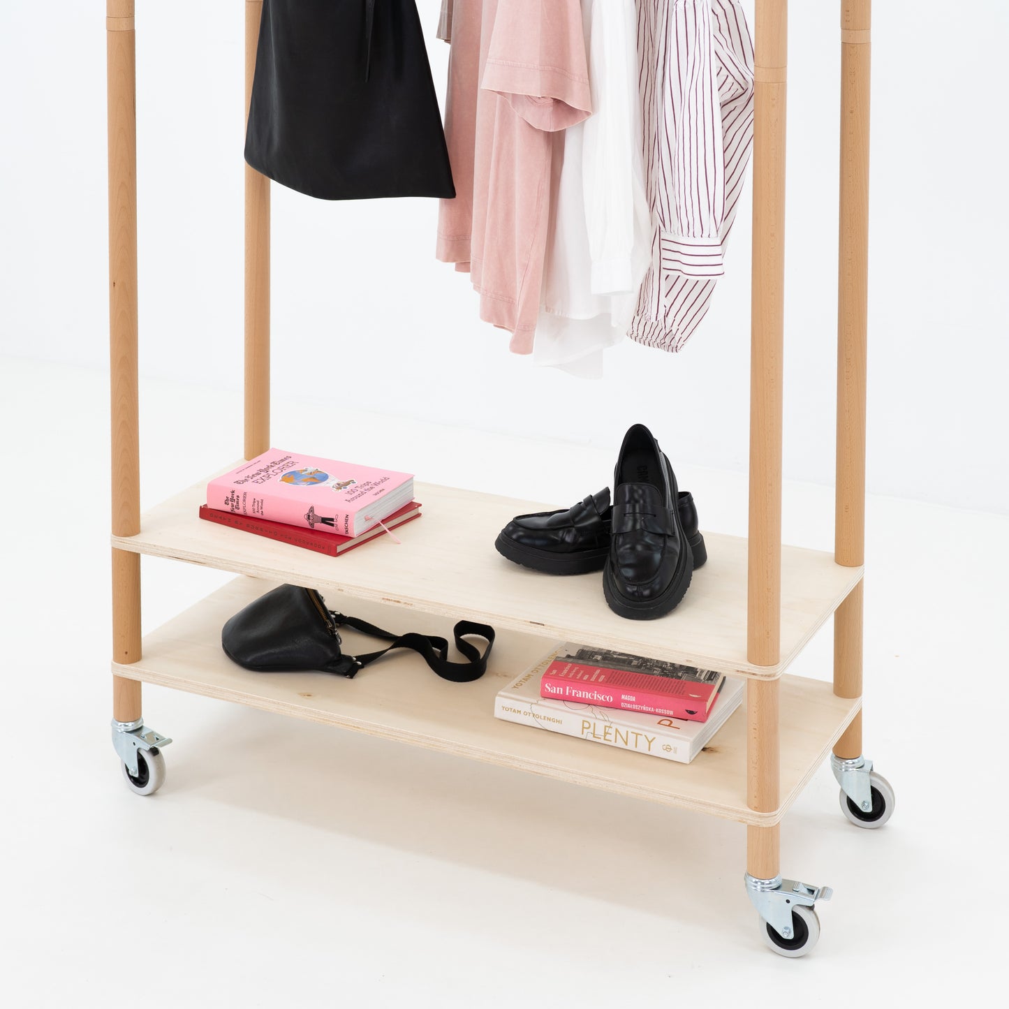 Minimalist wooden garment rack used at a fashion pop-up booth