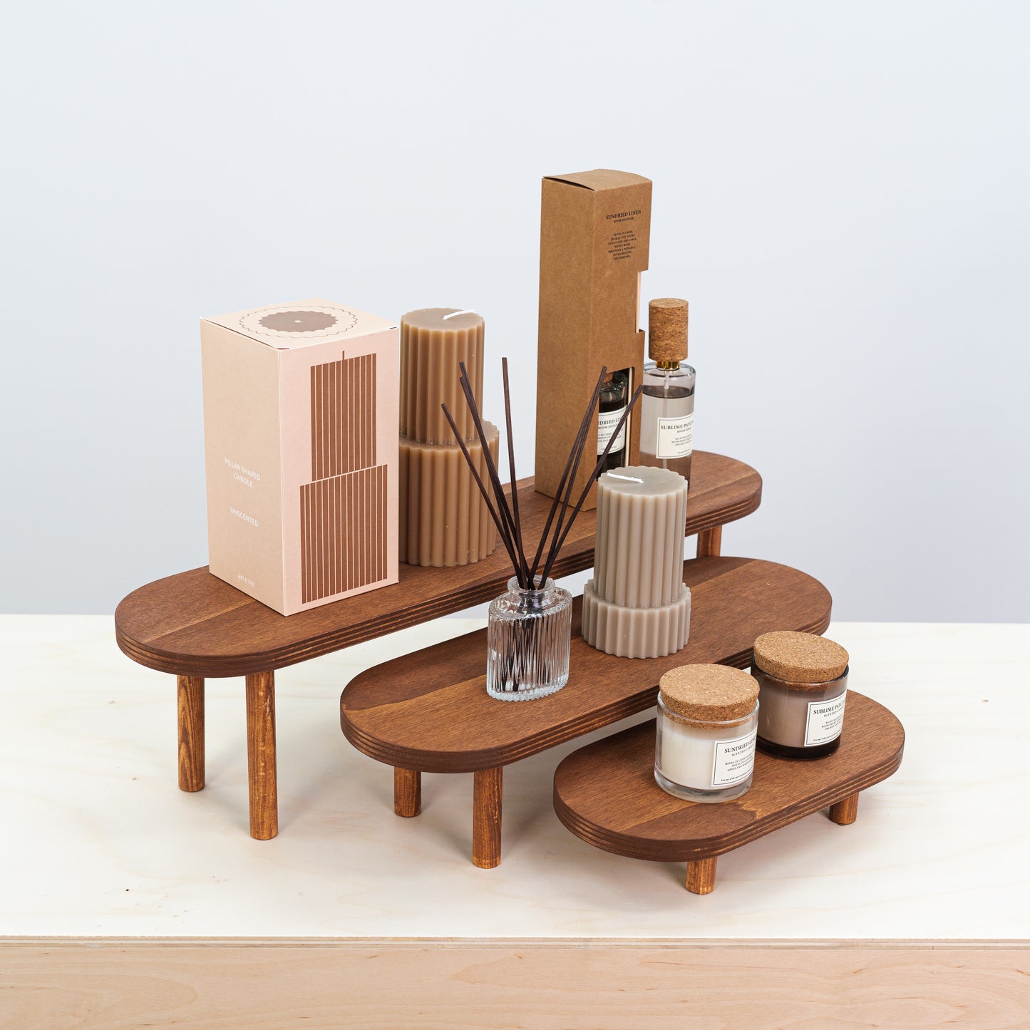 Warm brown display stands for candles, ceramics, and perfumes