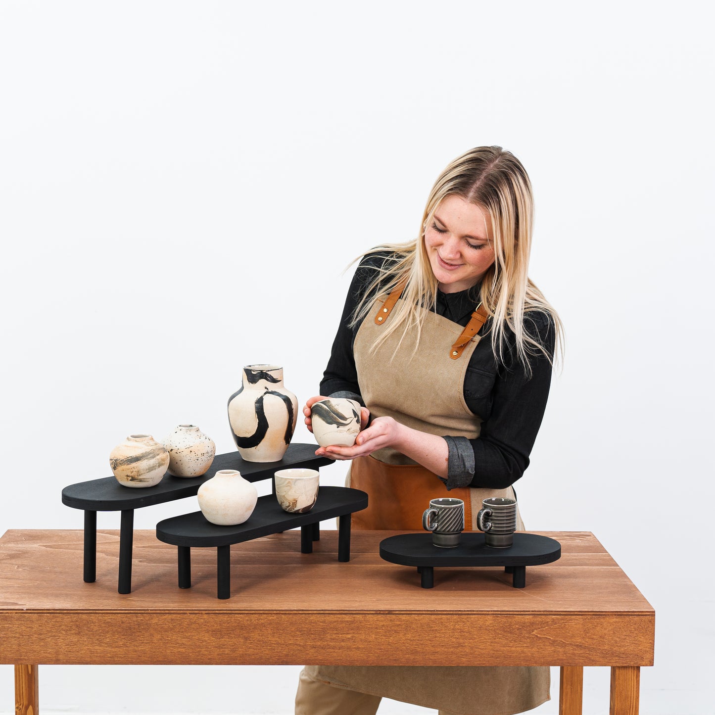 Black wooden riser set showcasing jewelry and cosmetics