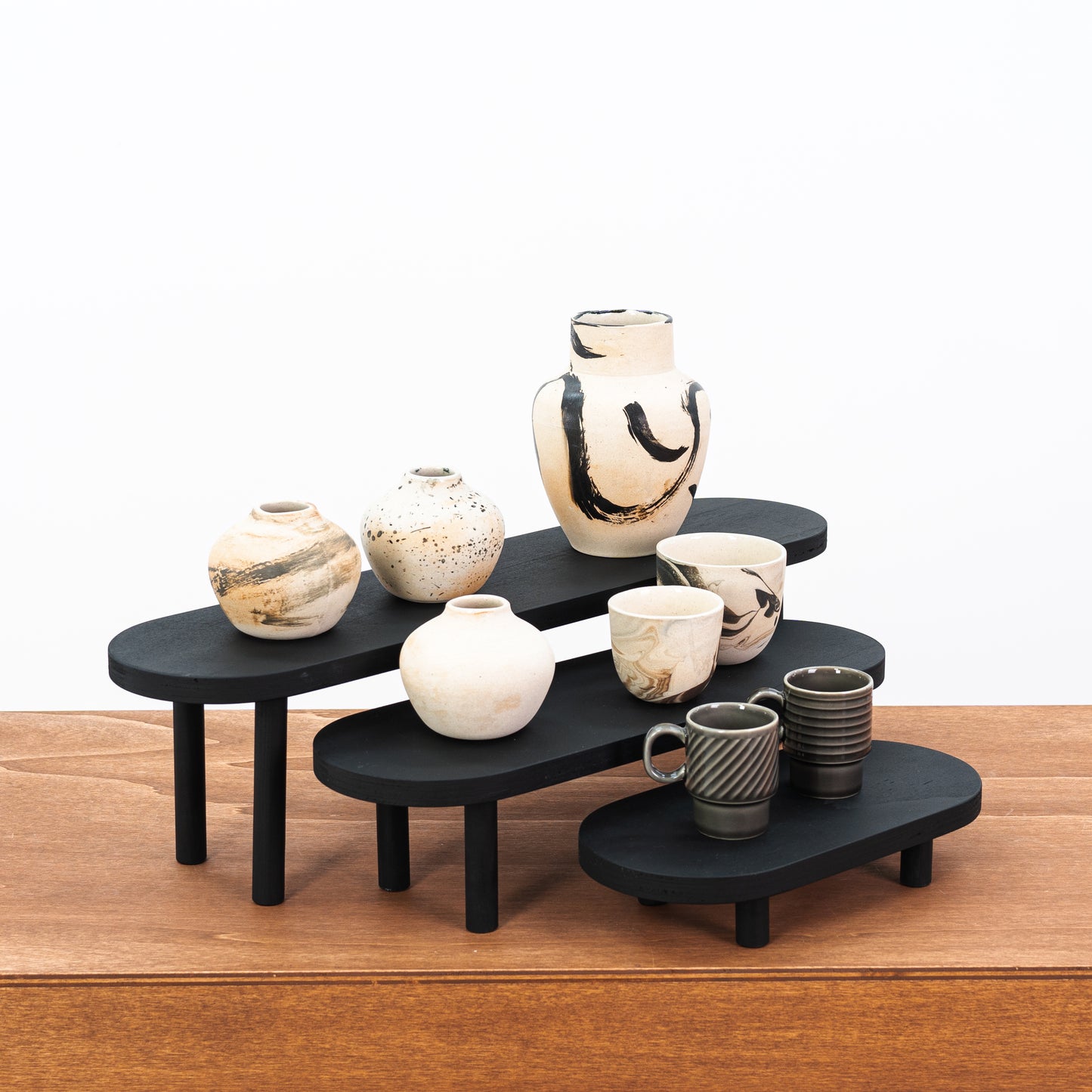 Set of 3 black wooden display risers for boutique product presentation