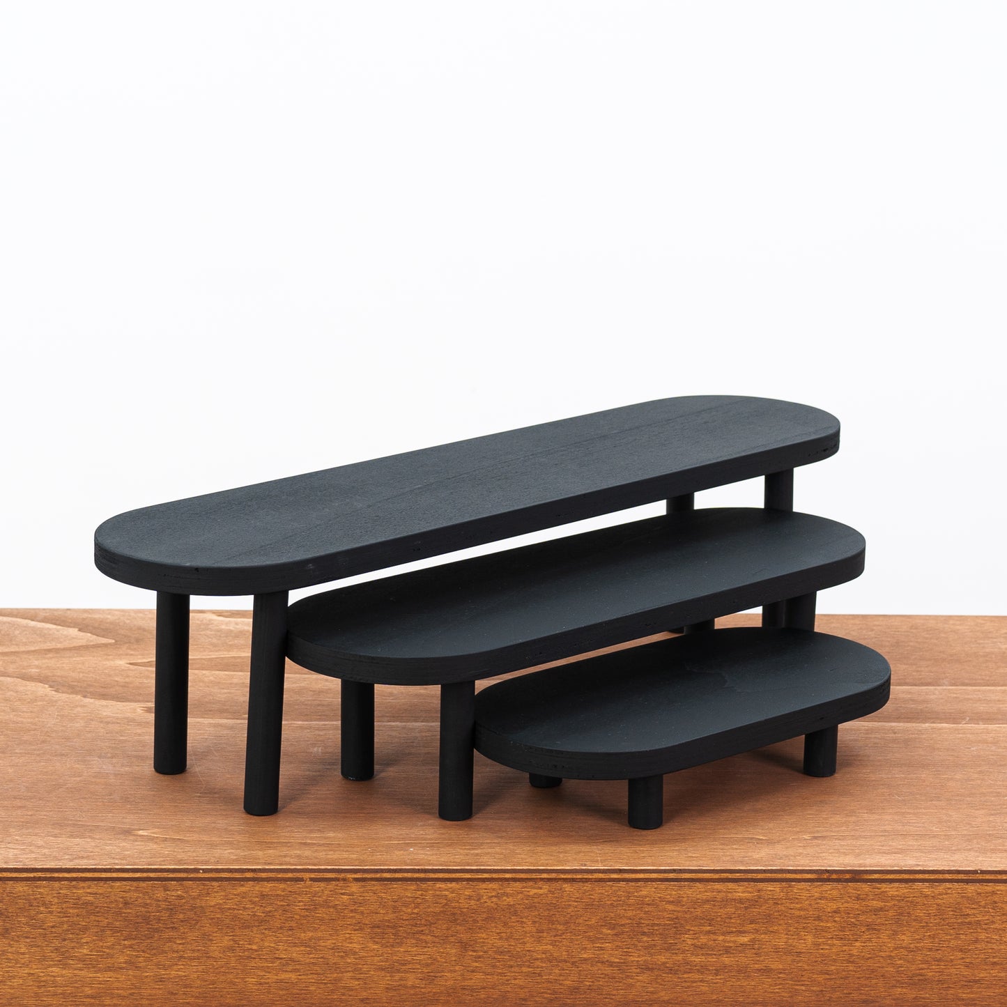 Elegant black display stands for candles and handmade ceramics
