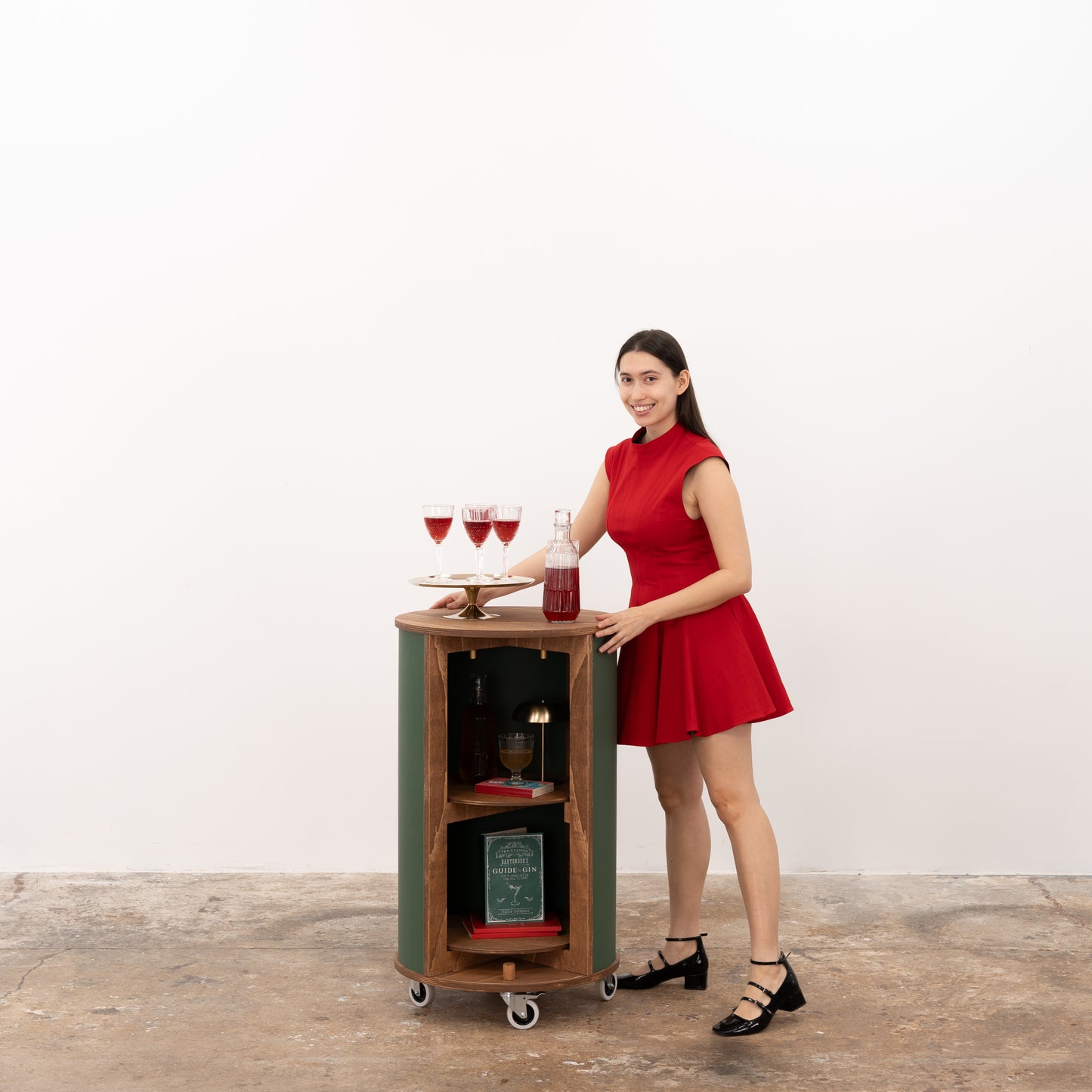Stylish green round host stand with custom shelving and storage, perfect for organizing and presenting products at any event.