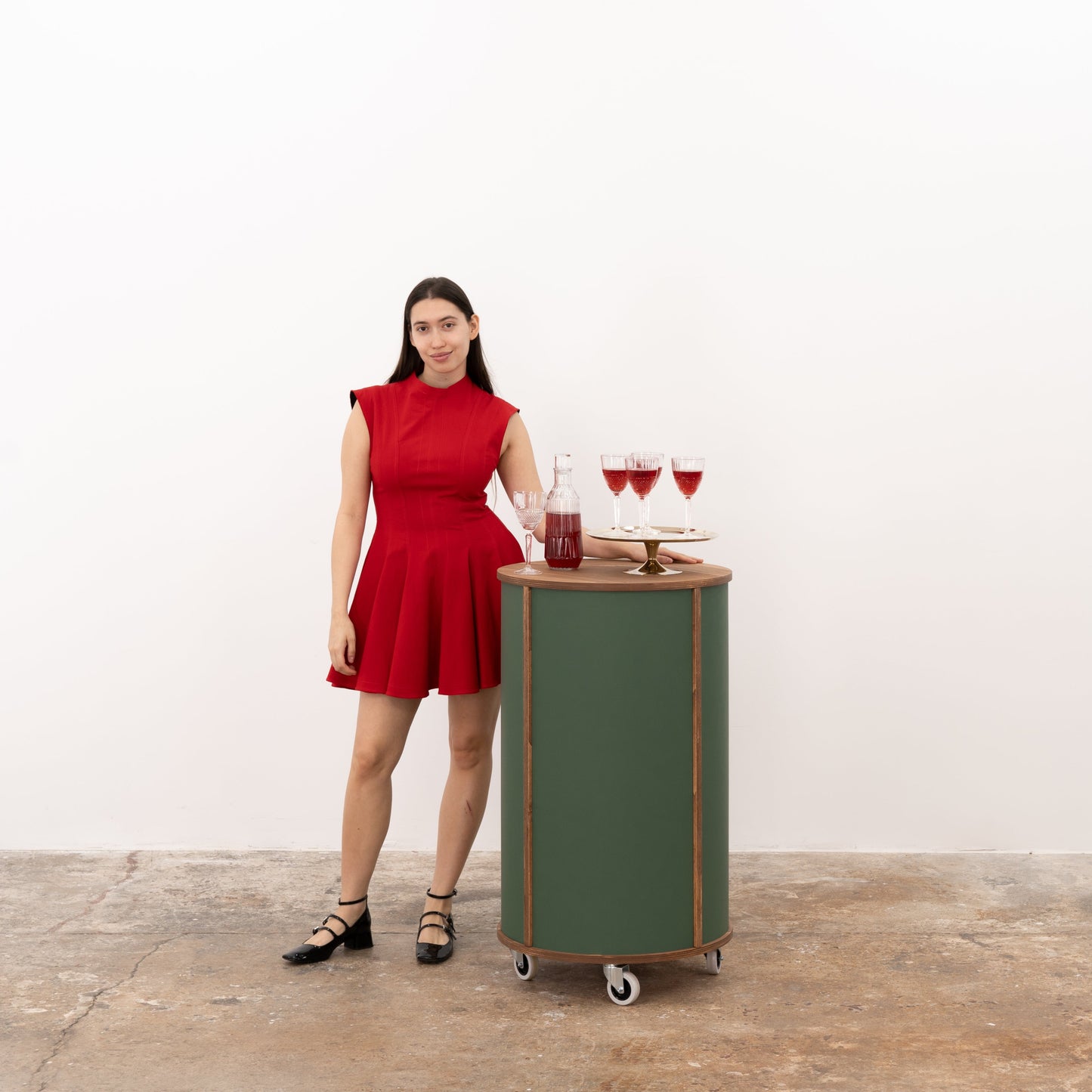 Green round host stand offering a clean, polished look with ample display space for showcasing products at retail and event spaces.