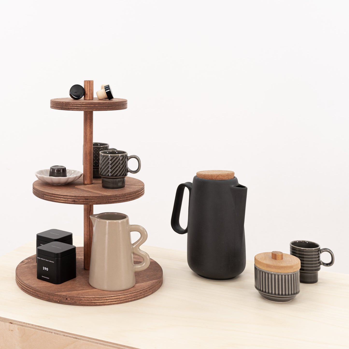 Three-tier display riser in coffee color showcasing small items like cosmetics and luxury candles.