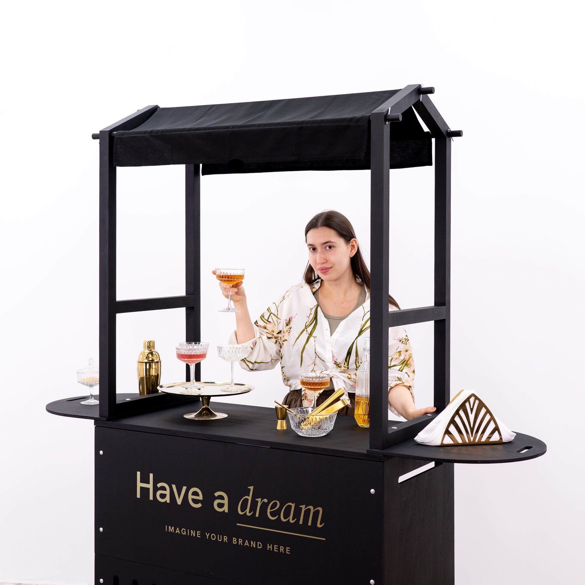 Modern cart with a black matte finish, displaying fine glassware and gold bar accessories, ideal for upscale events.