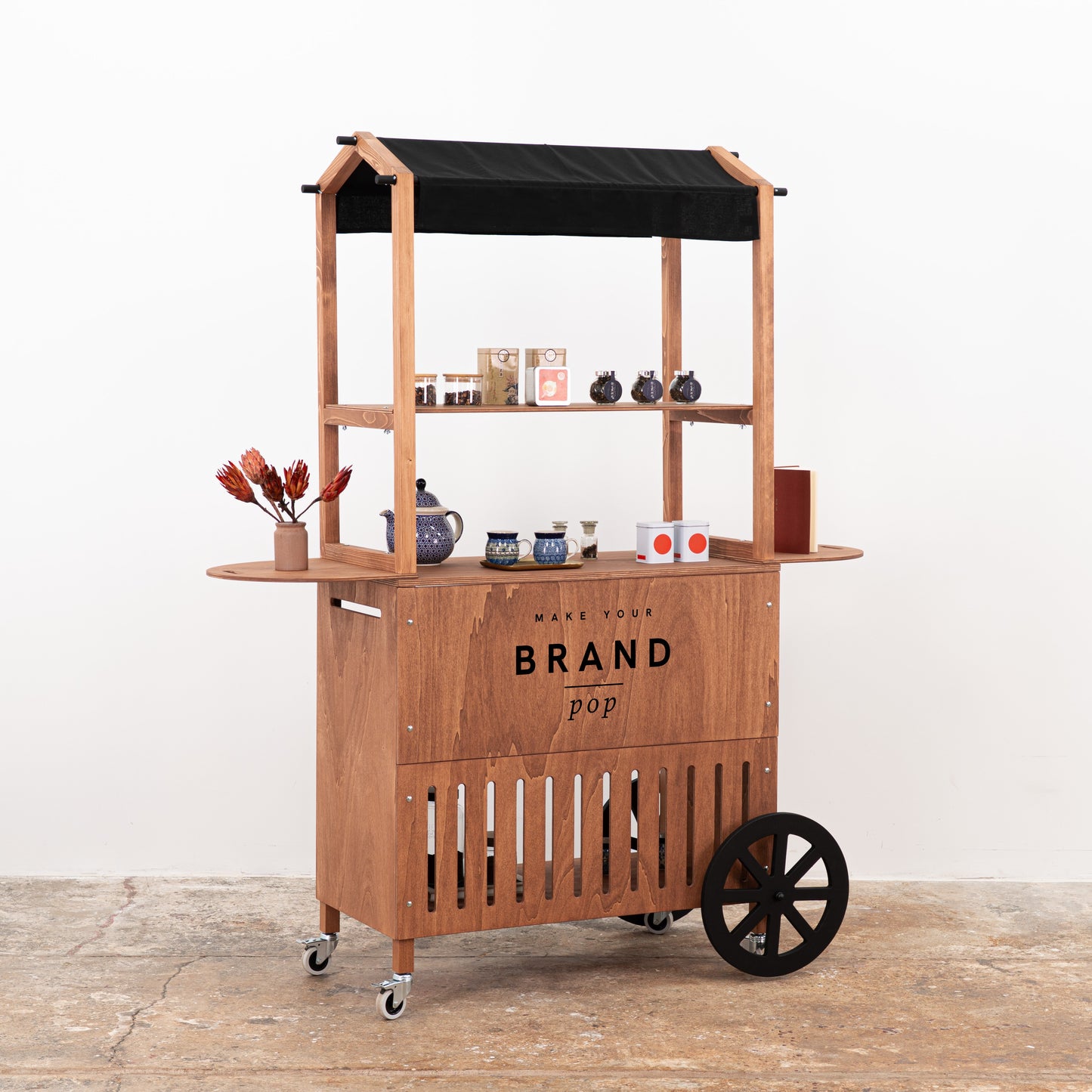 Coffee wood vendor cart with black awning and ceramic product display