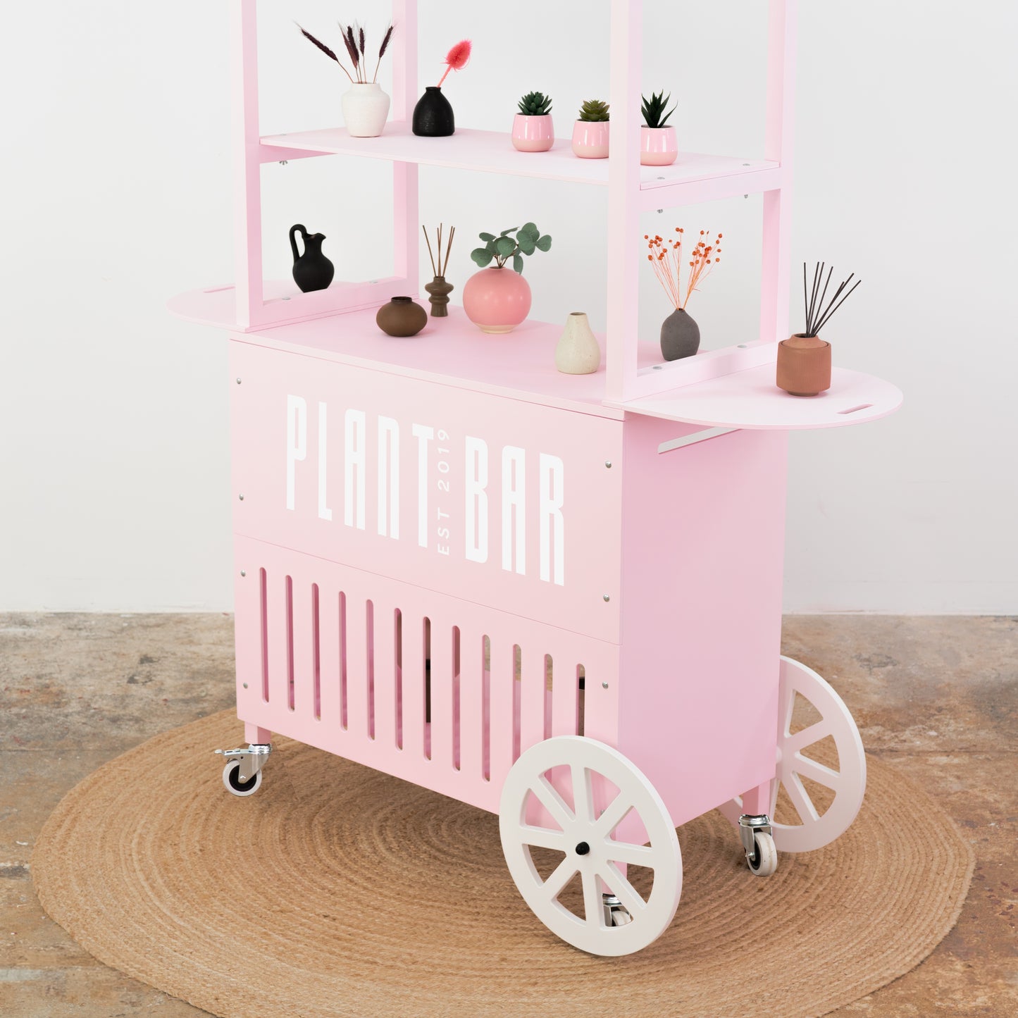 Soft pink event cart with white wheels – floral decor and plant bar setup
