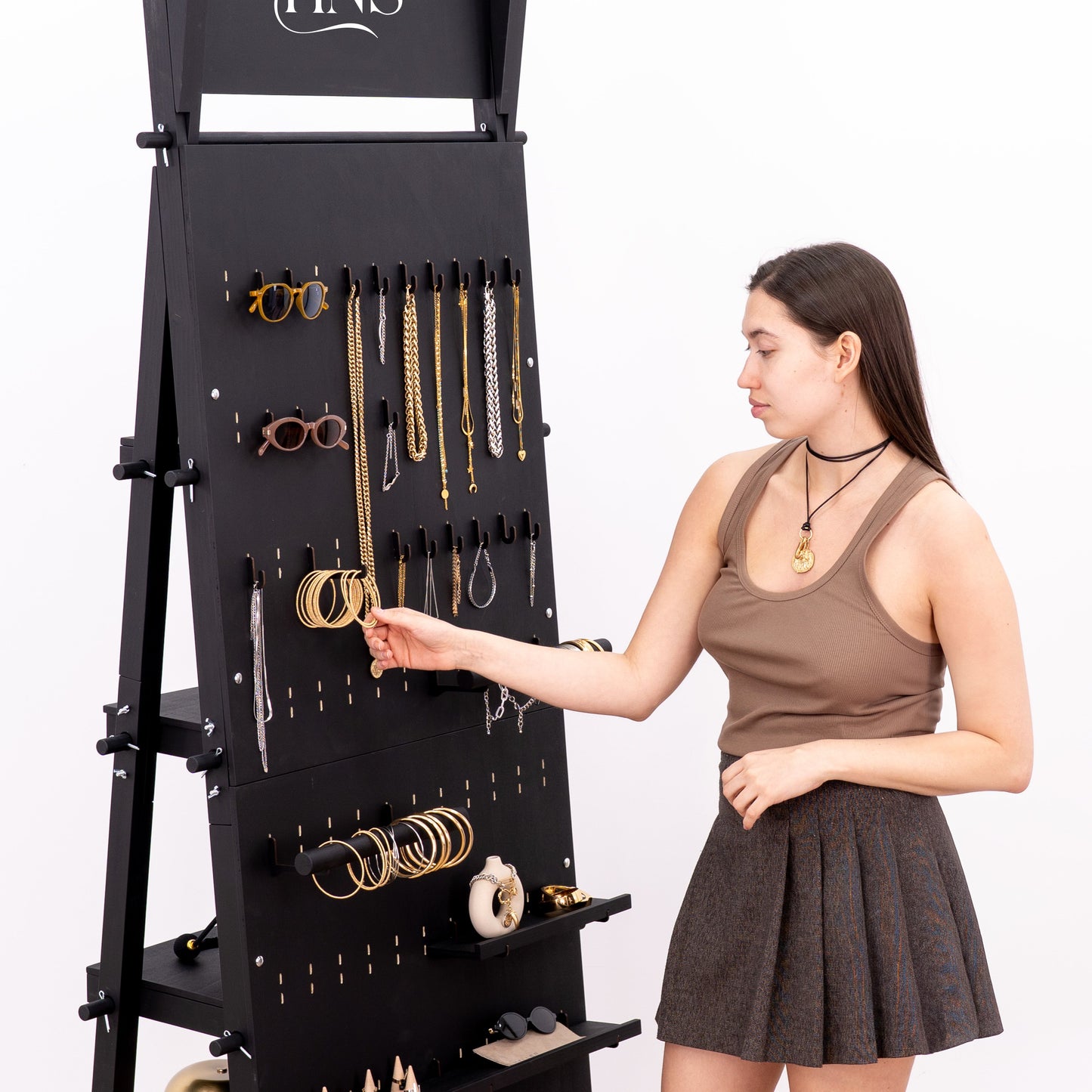 Vertical pegboard stand in matte black with assorted retail accessories
