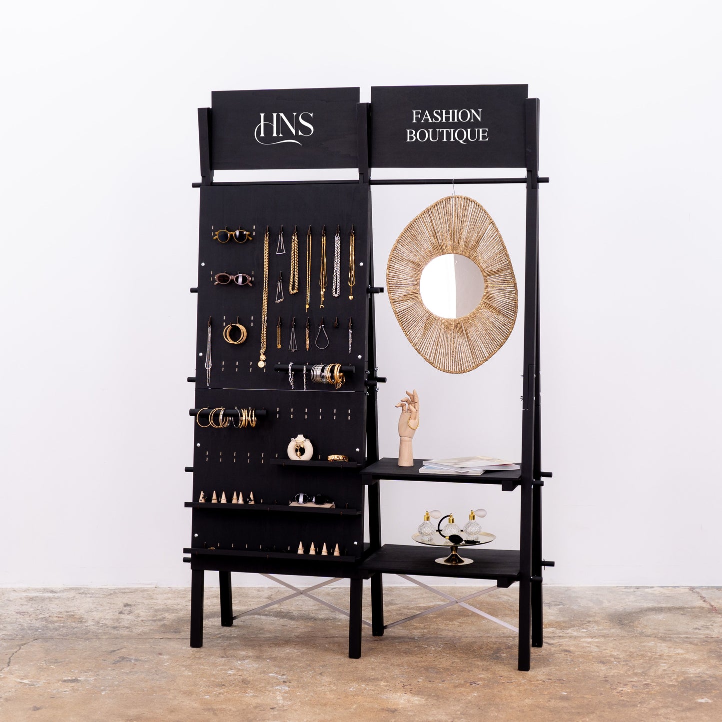 Matte black modular retail stand with pegboard and wooden shelves