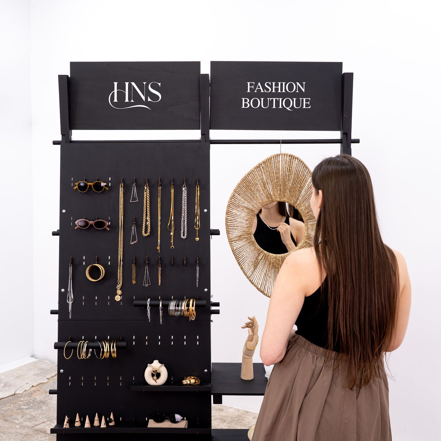 Jewelry and accessories displayed on freestanding pegboard wall