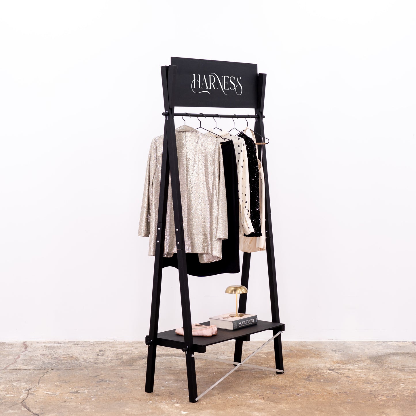 Retail display rack for garments with custom top panel in black wood