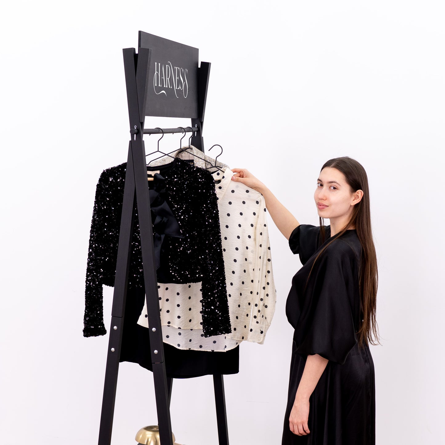 Minimalist black retail rack with robe, heels and accessories