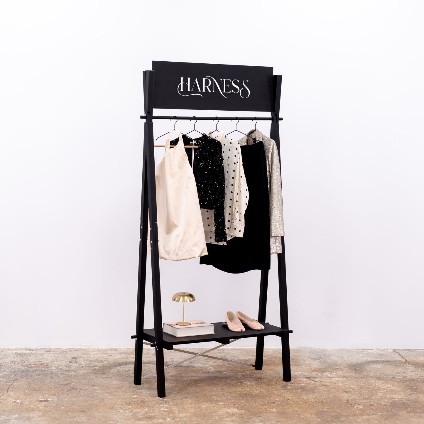 Lifestyle setup with black garment rack and elegant wardrobe pieces