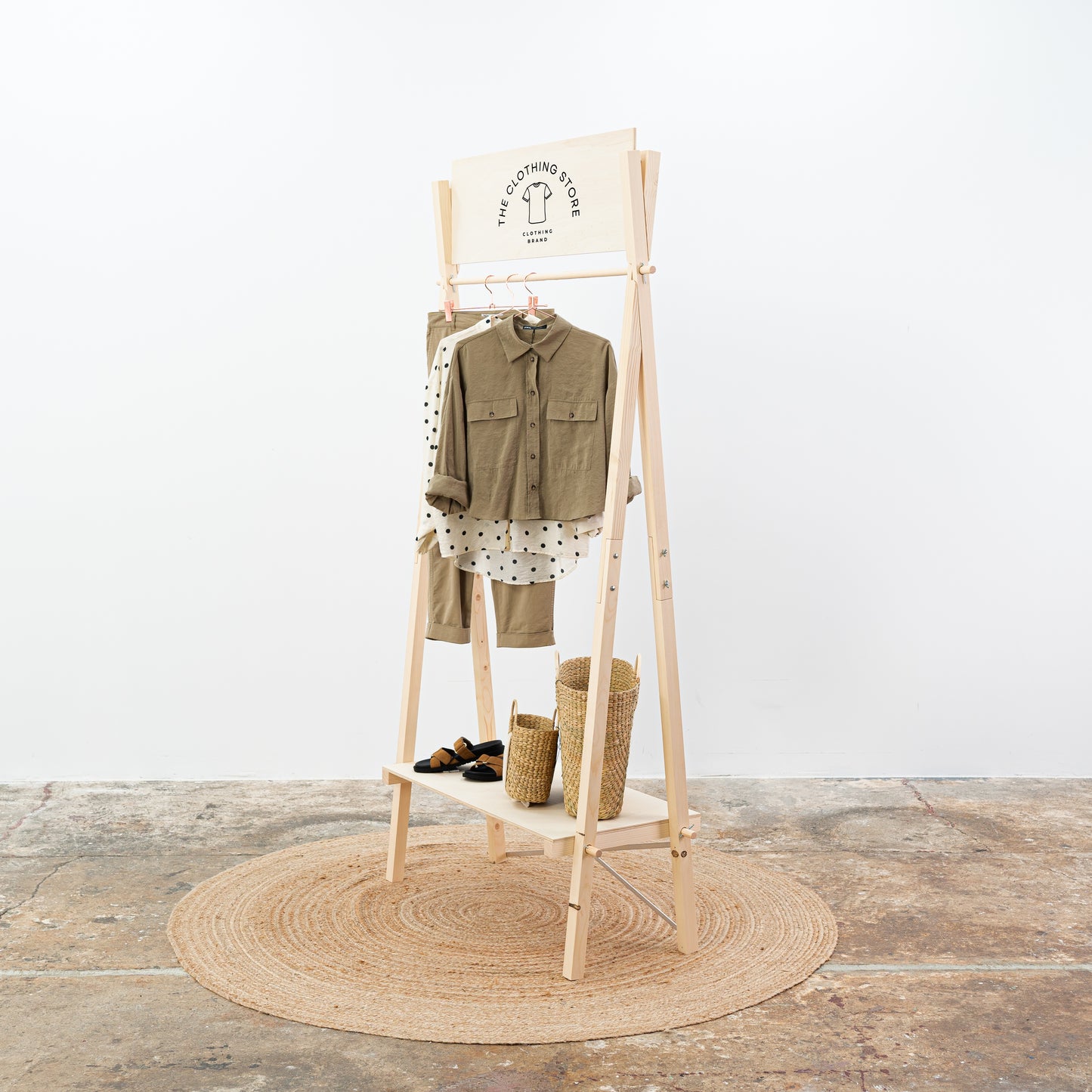 Freestanding wooden garment rack with branding board and shelf
