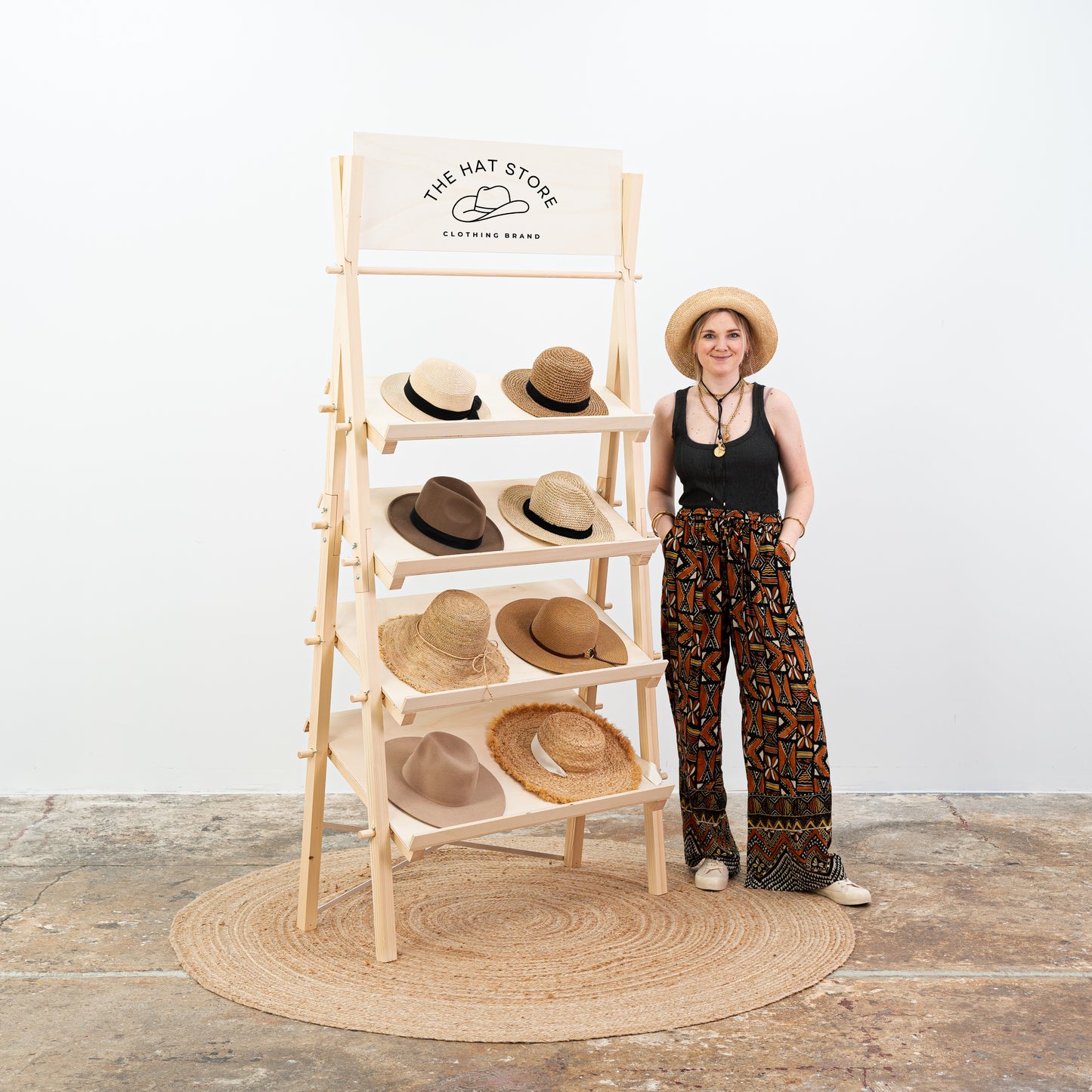 Woman standing next to a natural wood display rack with home decor accessories