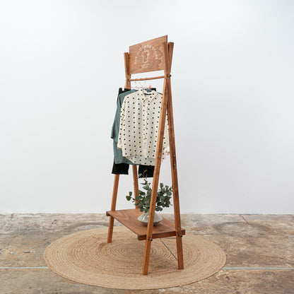 Coffee-colored freestanding clothing display stand with horizontal bar
