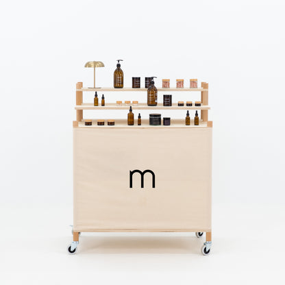 Front view of wooden checkout stand with branded fabric panel and tiered display shelves