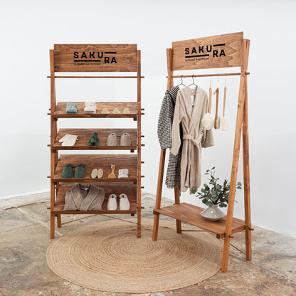 Fashion trade show stand with slanted shelves and garment rack

