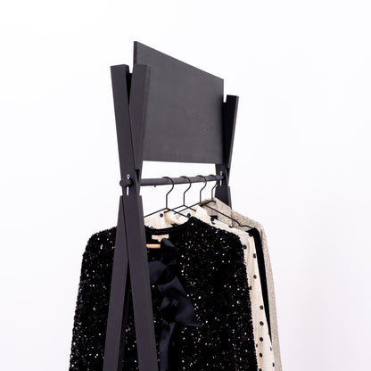 Minimalist black retail rack with robe, heels and accessories