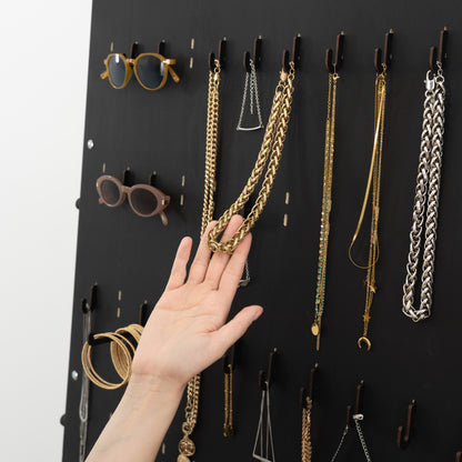 Foldable black wooden rack with hooks, trays and open hanging space
