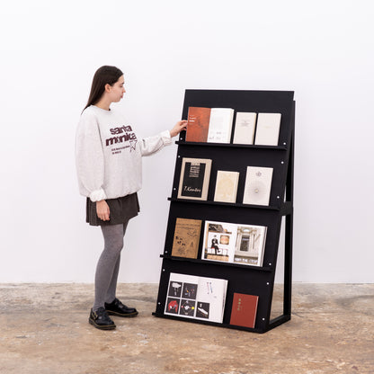 Dual black modular display stand showcasing art magazines and editorials
