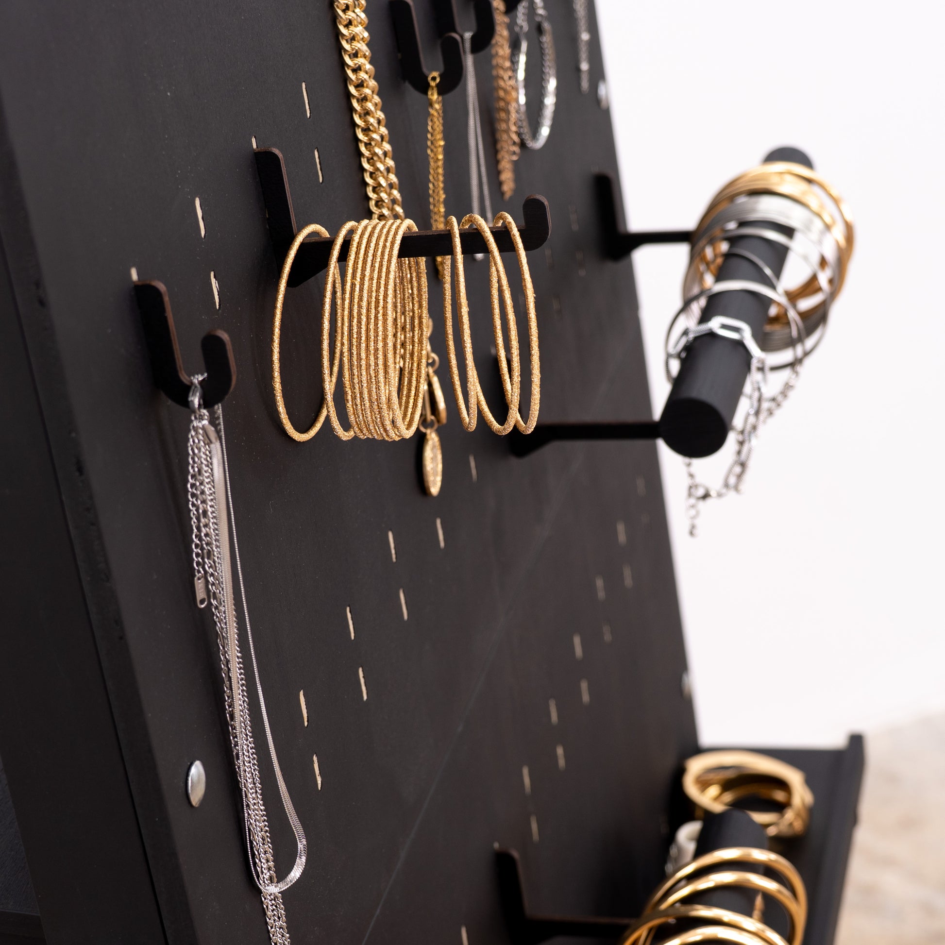 Black long hooks for pegboards, providing a flexible and modern display solution for larger items in commercial and event setups.