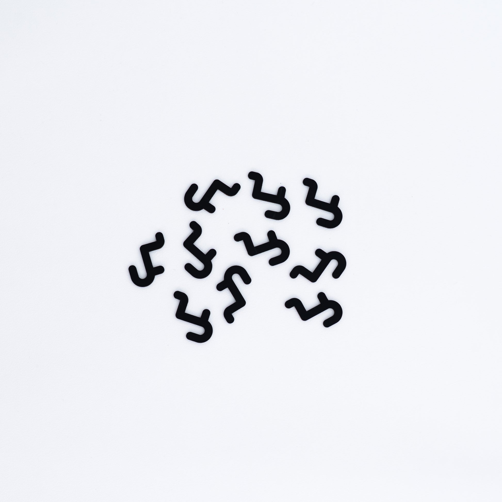 Set of 10 short hooks in black, designed for pegboards, perfect for displaying accessories, small products, and merchandise in an organized manner.