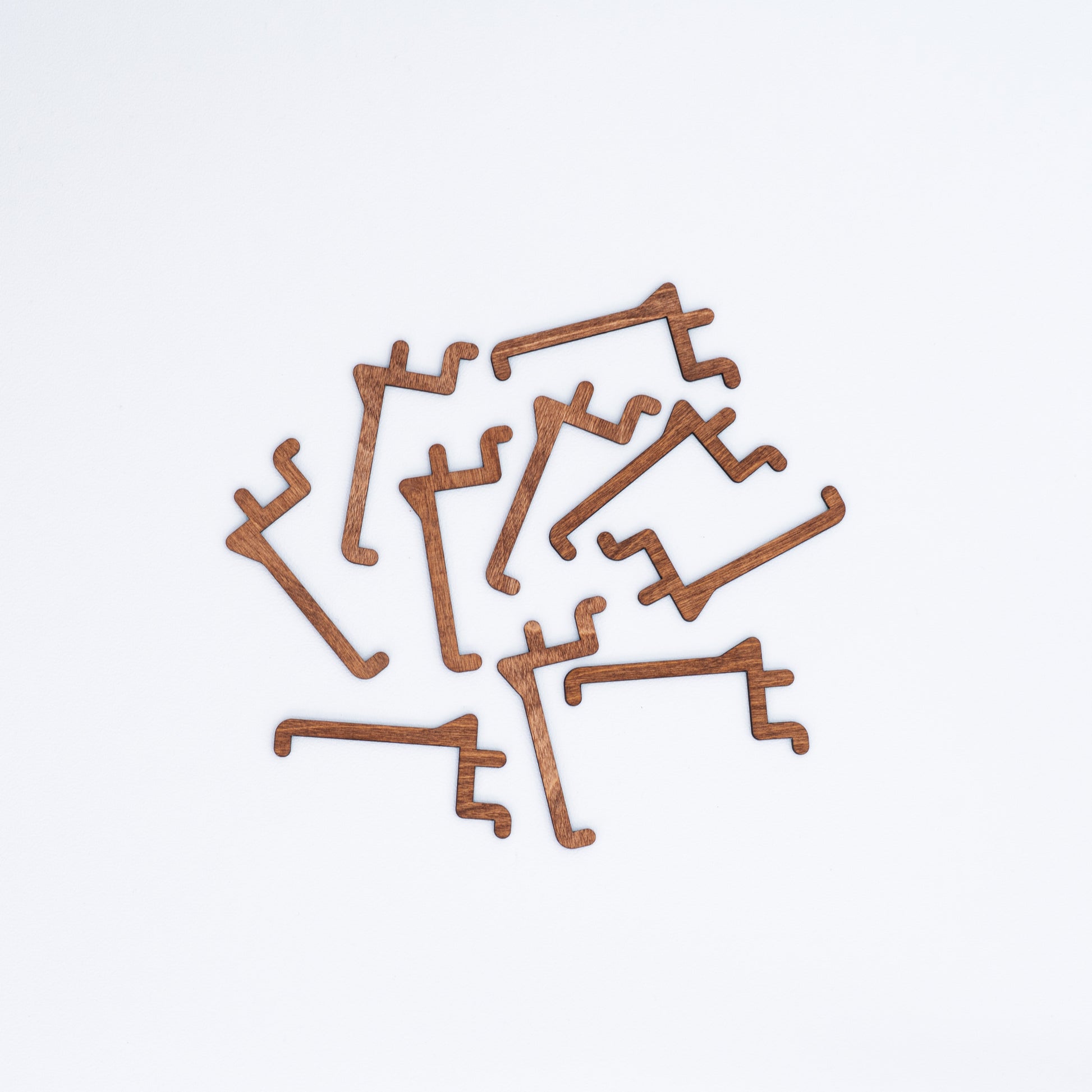 Set of 10 long hooks in Coffe color for pegboards, ideal for displaying items such as bags and accessories.