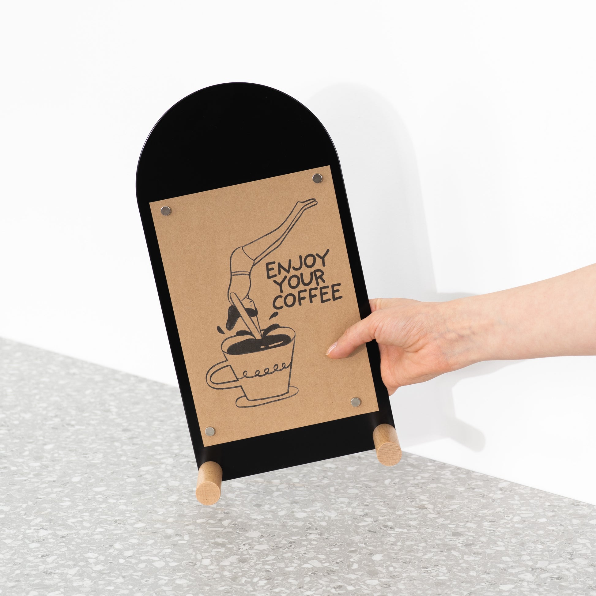 Stylish vertical board for tabletop messaging with natural wooden support rods

