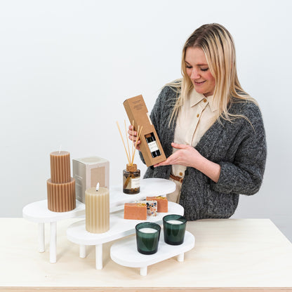 Three-tier white wooden risers for clean and organized product displays


