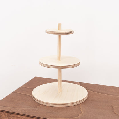 A versatile three-tier riser in natural wood, ideal for displaying jewelry, perfumes, or cosmetics at retail spaces or pop-up events.