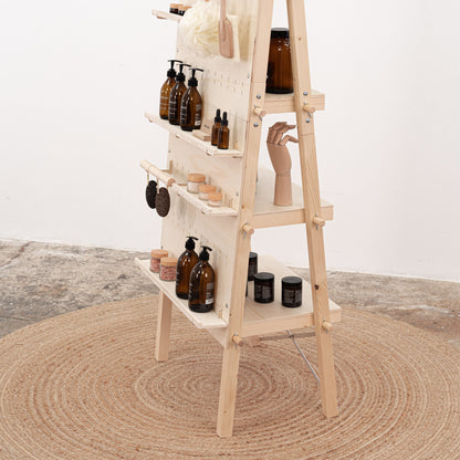 Customizable natural pegboard stand for retail setups, complete with logo panel and back shelving for added functionality.