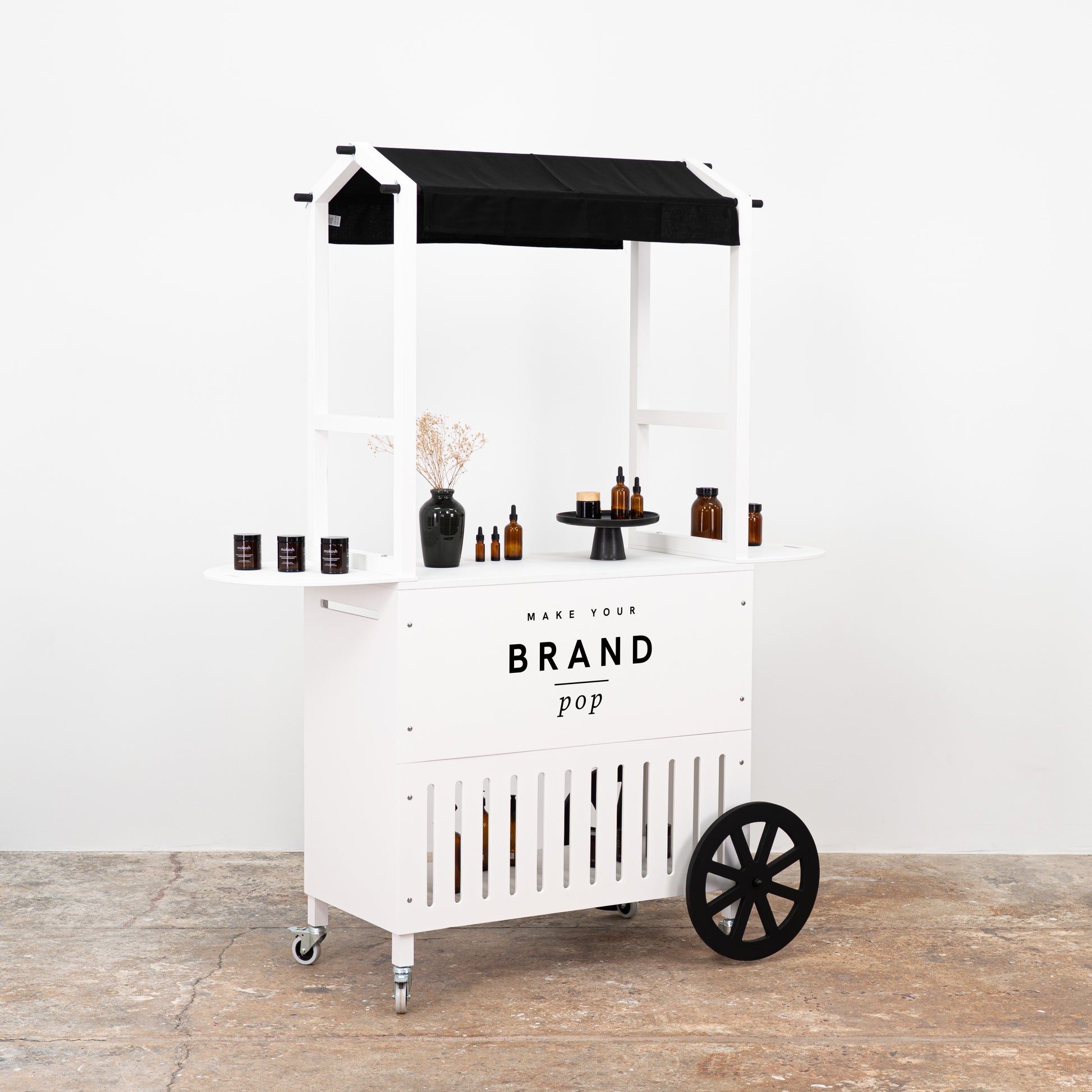 Stylish portable cart with black wheels and branding space, designed for retail displays and product presentation.
