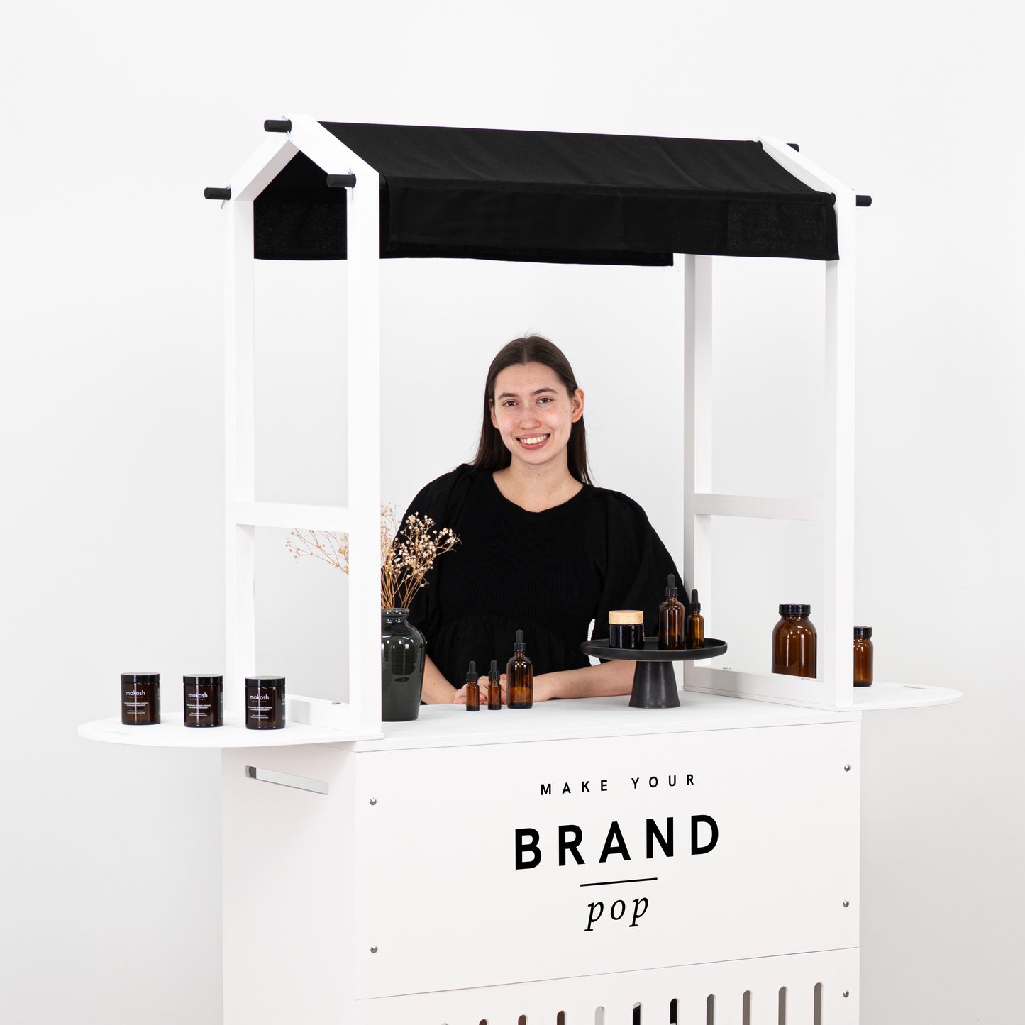 Modern black and white cart with functional shelves, perfect for showcasing and organizing products at events.