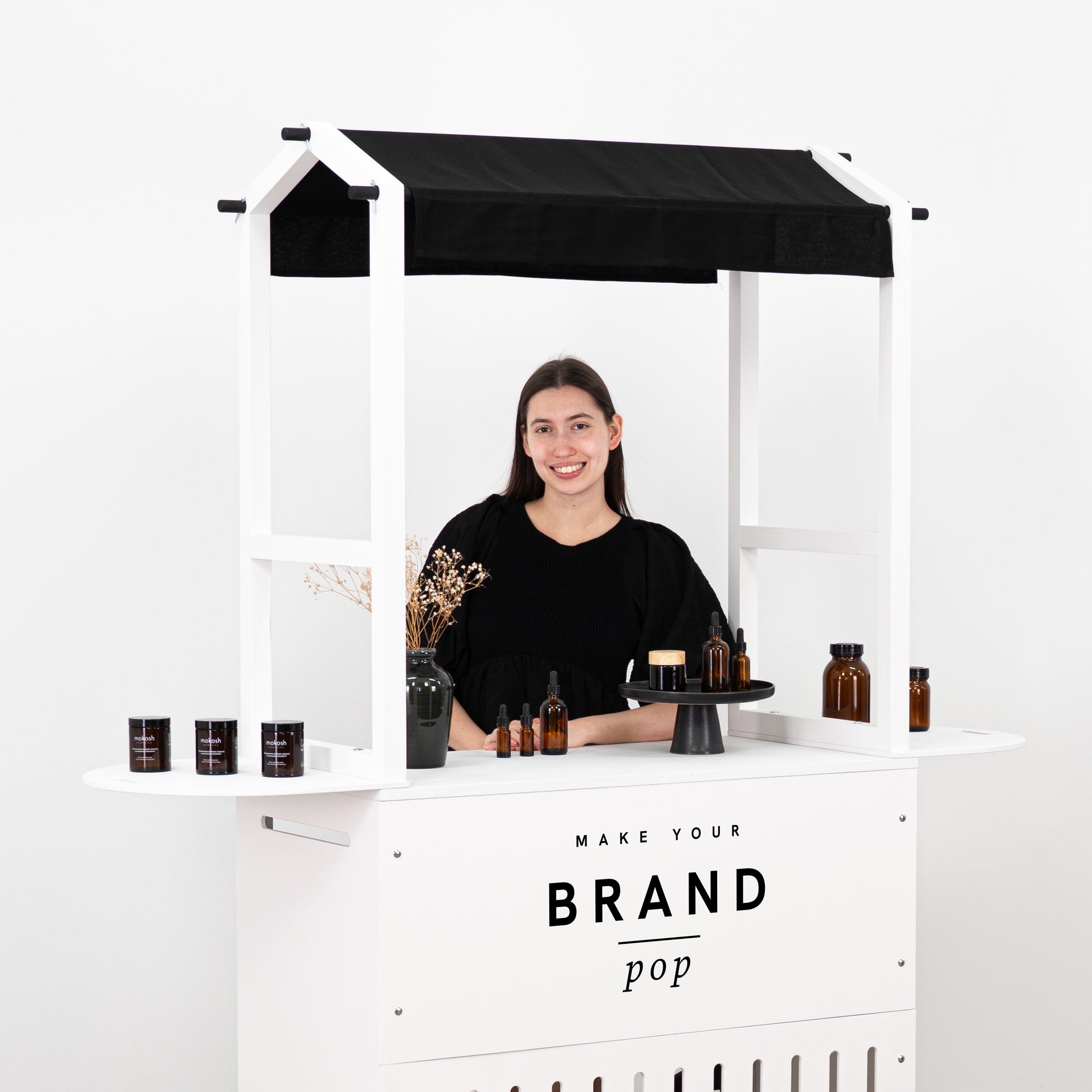 Modern black and white cart with functional shelves, perfect for showcasing and organizing products at events.