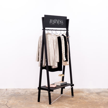 Retail display rack for garments with custom top panel in black wood