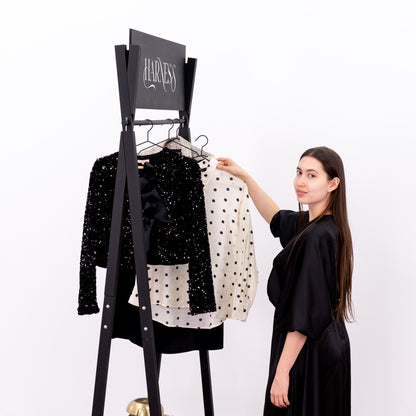 Minimalist black retail rack with robe, heels and accessories