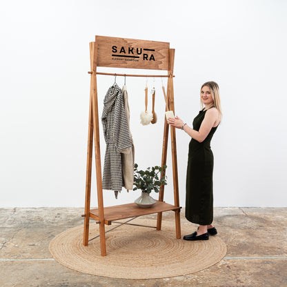 Foldable garment display stand with custom Sakura logo and lower shelf