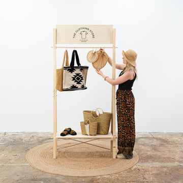Natural wood garment rack with shelf and branding panel Natural wood garment rack with shelf and branding panel