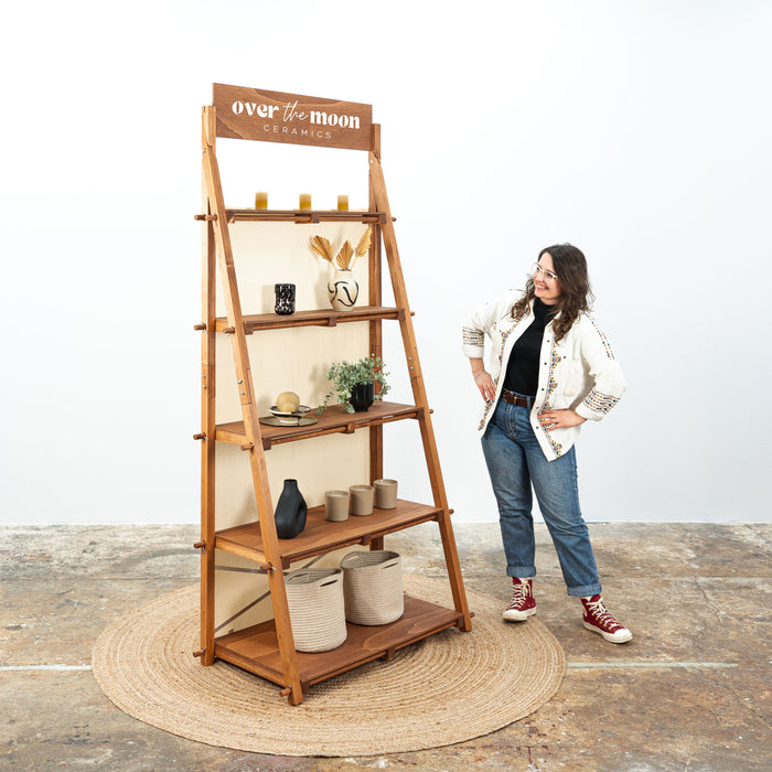 Coffee-colored portable shelving unit with slanted wooden shelves for artisan markets