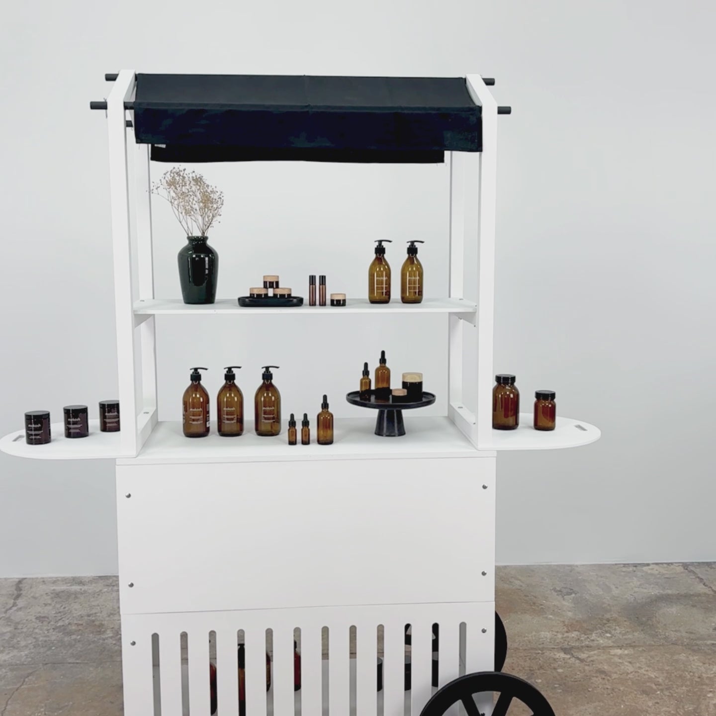Video showcasing a white mobile cart with a stylish design, perfect for displaying beauty products at trade shows and events.
